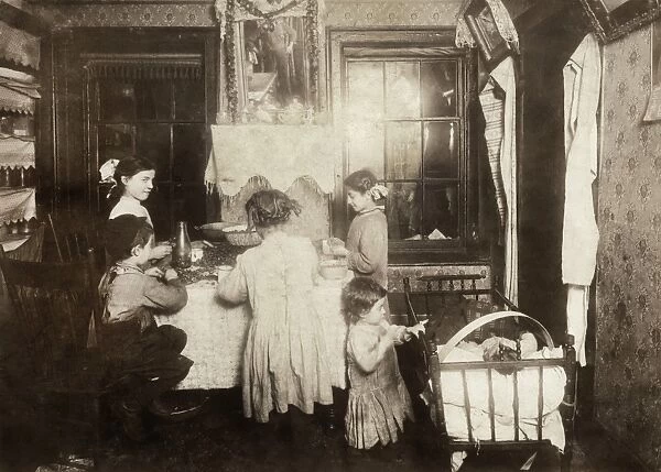 HINE: HOME INDUSTRY, 1911. Young children shelling nuts in a tenement apartment