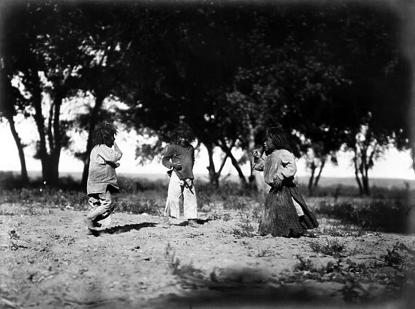 NAVAJO CHILDREN, c1905. Three Navajo children playing, with cottonwood trees in the background