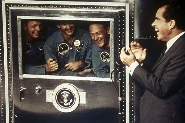 SPACE: APOLLO 11. President Richard M. Nixon applauds astronauts Neil Armstrong, Michael Collins, and Edwin Buzz Aldrin in the quarantine trailer, 1969