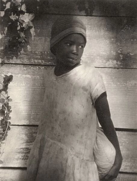 ULMANN: GIRL, c1930. Portrait of a young girl holding a bag. Platinum print by Doris Ulmann