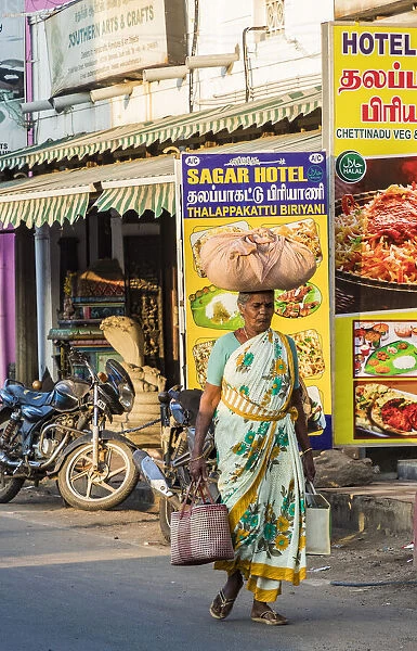 A shopper carrying a load on her head at Mamallapuram in Tamil Nadu, India