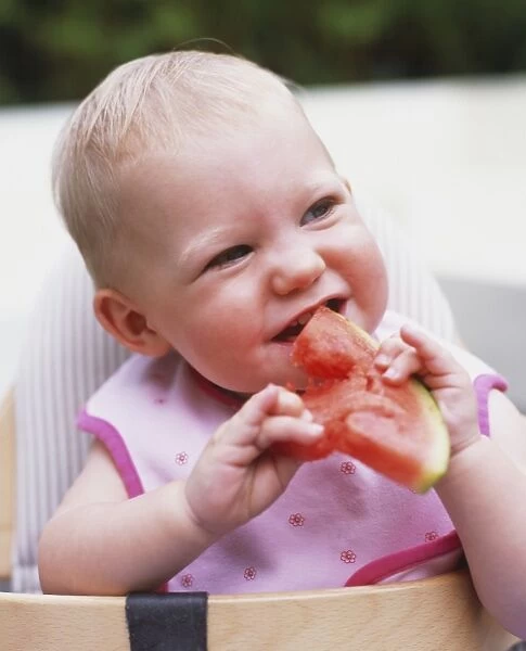 Baby eating a slice of watermelon