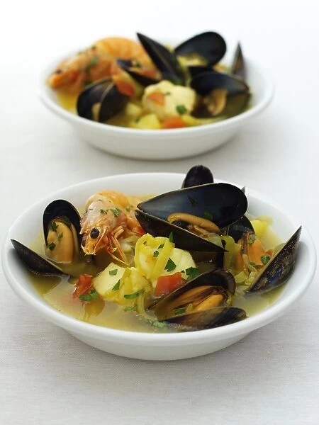 Two bowls of fish soup with saffron and fennel, close-up