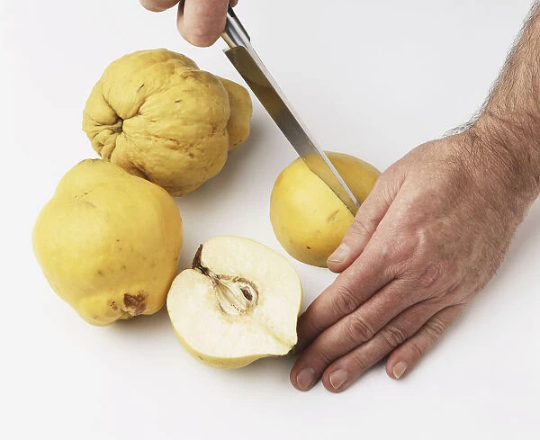 Chopping quinces with a sharp knife, close-up