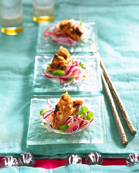 Glass noodle salad with black pepper chicken served on three glass dishes with chopsticks on a turquoise tablecloth