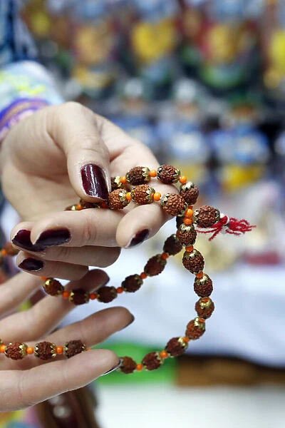 Hand of prayer holding rudraksha beads or rosary. Dubai. United Arab Emirates