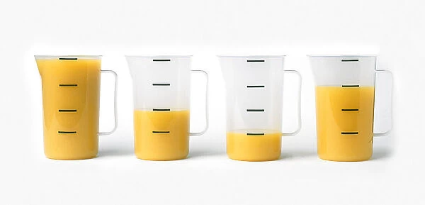 Jugs filled with different quantities of orange juice