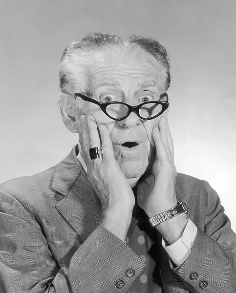 Mature man with glasses looking shocked