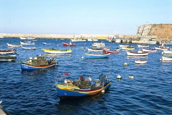 Portugal, Sagres, small colourful fishing boats moored on water in harbour