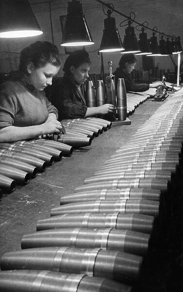 Soviet artillery shells undergoing quality control inspection by civilian women workers at a munitions plant during world war2
