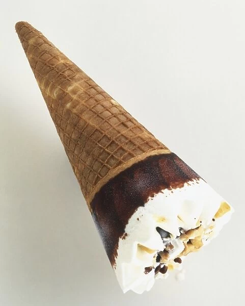 Vanilla ice cream sprinkled with nuts and coated with chocolate, in a cone