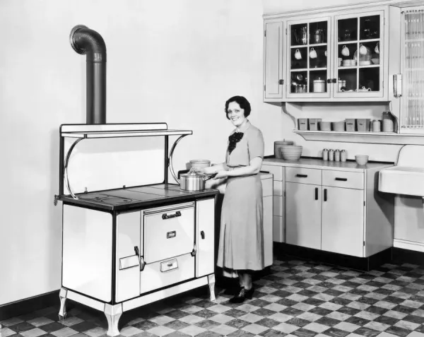 A woman stands in her kitchen cooking on her Monarch stove
