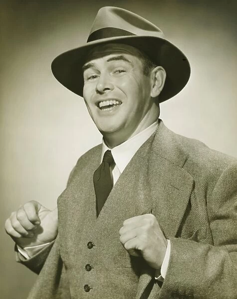 Businessman holding thumbs in waistcoat, smiling, (B&W), portrait