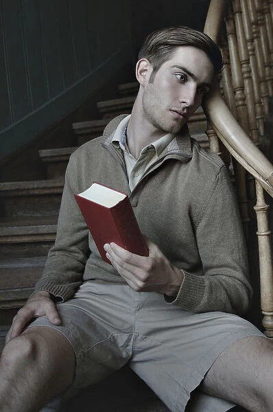Man with book in a stairwell, nostalgic portrait