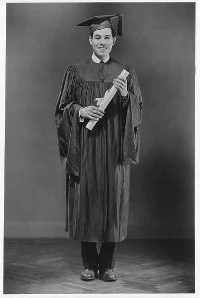 Studio portrait of a man in graduation cap and gown