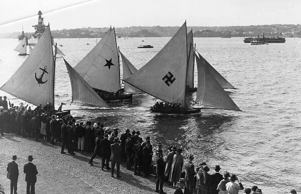 Sailboats. circa 1910: A crowd gathers to watch yachts in the harbour