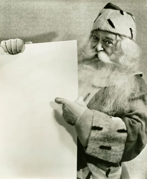 Santa Claus holding blank sheet of paper, (B&W), portrait