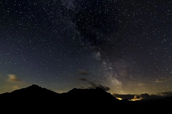 Starry sky with the Milky Way over a mountain landscape, with light pollution, Safien, Canton of Graubunden, Switzerland