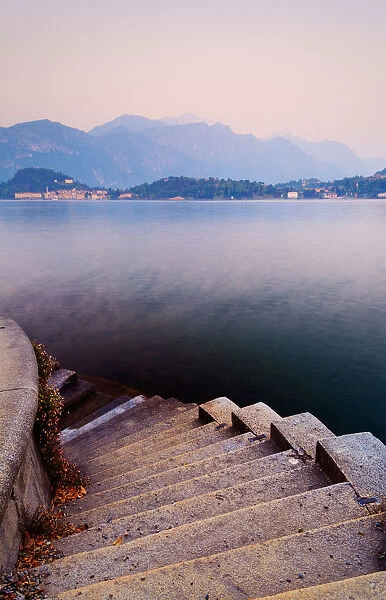 Tranquil. Street lamps light up park pathway along most beautiful lakes in Italy