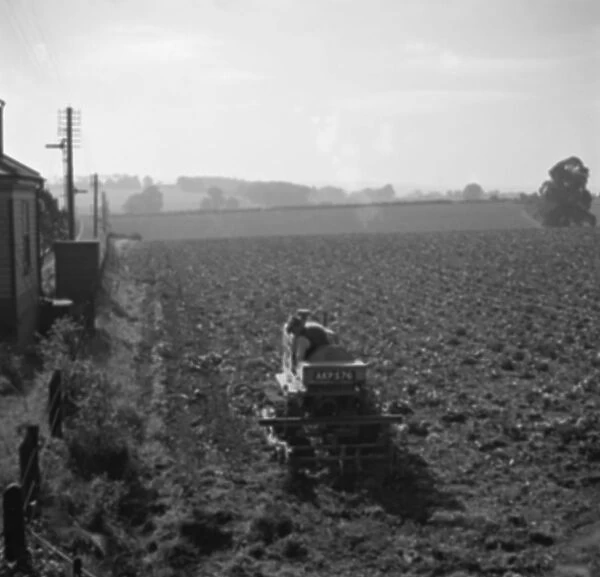 A farmer on a tractor ploughing a field. 1936