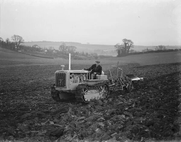A farmer using his diesel caterpillar tractor to plough a field in Farningham, Kent