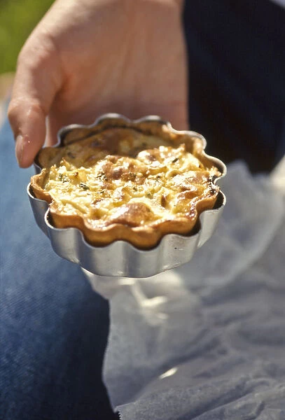 Home made quiche in its tin held in the hand credit: Marie-Louise Avery  /  thePictureKitchen