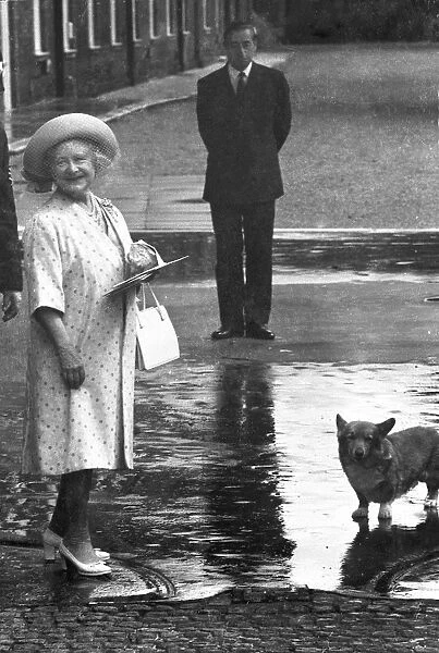 The Queen Mother outside her home at Clarence House on her 84th birthday with a royal corgi