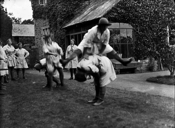 Members of the First World War Womens Land Army playing leap frog. Tregavethan Farm, Truro, Cornwall. 13th September 1918