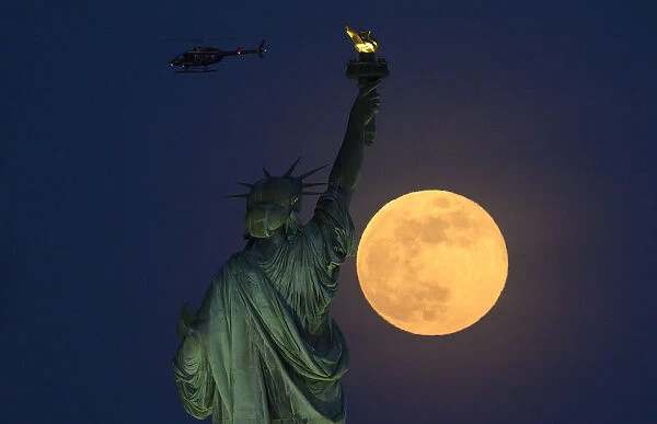 Us-Full Moon-Statue. A helicopter flies past as the full moon rises behind