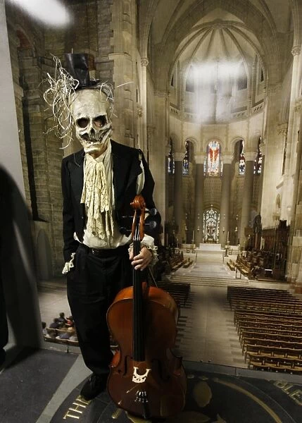 Us-Halloween-Ghouls. A charactor in a ghoulish mask with a cello backstage