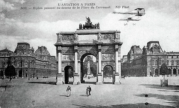 Biplane flies over Place du Carrousel, Paris