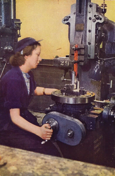 Kathleen McCarthy, formerly a hairdresser, operating a machine for slotting the case striker body of a six-pounder gun at a British Royal Ordnance Factory, World War II, c1942 (photo)