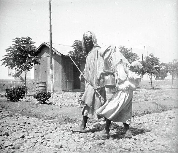 Morocco, Gharb-Chrarda-Beni Hssen, Mechra Bel Ksiri: A peasant couple on a stone road, 1910