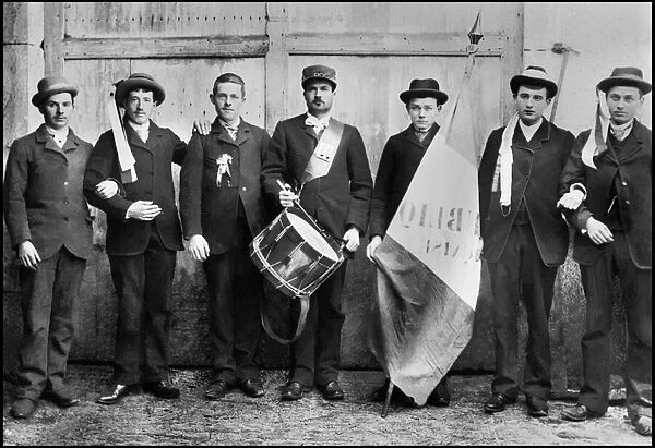 Portrait of a group of conscripts, wearing the cockade and the French flag, accompanied by a drum. in the Abbey of Septfontaines (Haute Marne). Photograph, circa 1870, by Paul Emile Theodore Ducos (1849-1913)