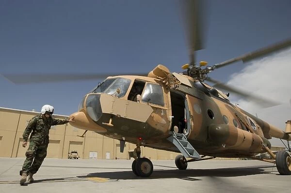 An Afghan Air Force aerial gunner makes final checks on a Mi-17 helicopter