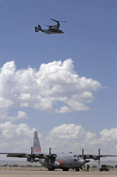 A CV-22 Osprey flies over a C-130 Hercules