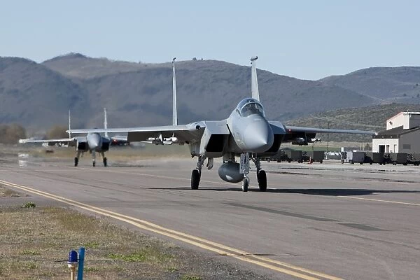 Two F-15 Eagles taxi out to take off on a training mission