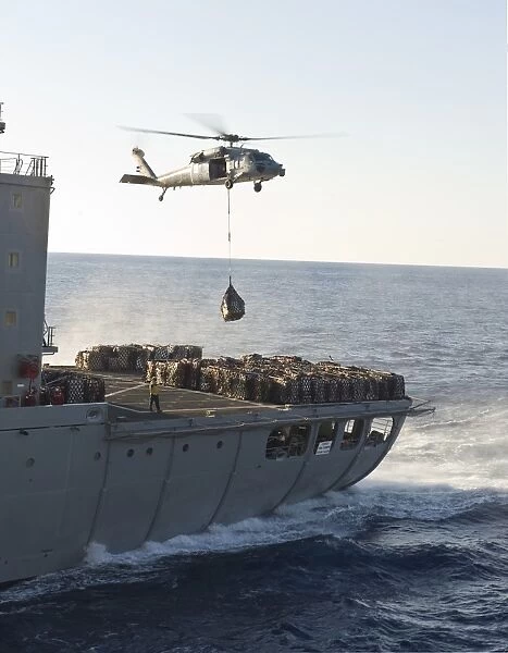 An MH-60S Sea Hawk helicopter carries supplies