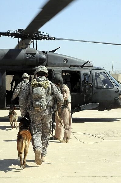 Military working dog handlers board a helicopter