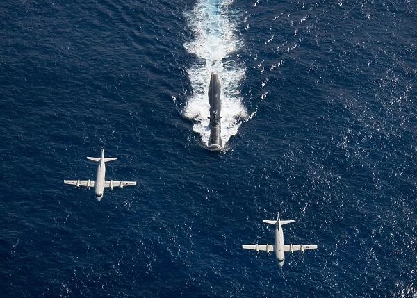 Two P-3 Orion maritime surveillance aircraft fly over attack submarine USS Houston