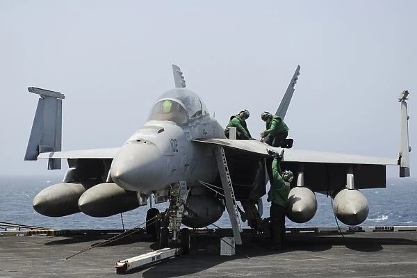 Sailors perform maintenance on an F / A-18F Super Hornet