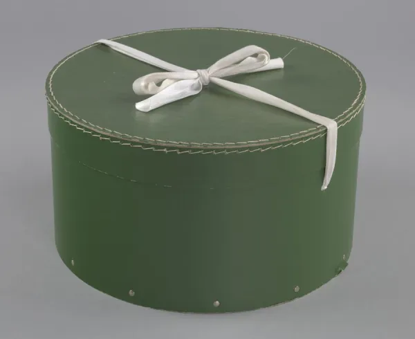 Green circular hatbox with lid from Maes Millinery Shop, 1941-1994. Creator: Unknown