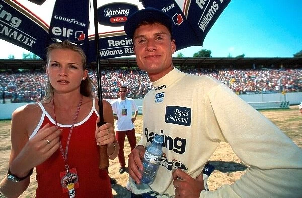 Formula One World Championship: David Coulthard Williams with his girlfriend Andrea Murray shelter from the heat prior to the race