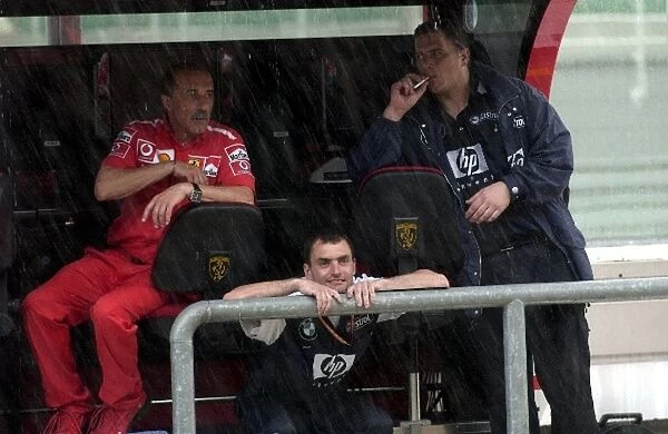 Formula One World Championship: Ferrari and Williams engineers shelter from the rain