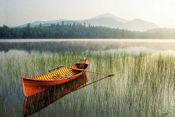 NA. An Adirondack Guide Boat in a calm lake with Whiteface Mountain in the background