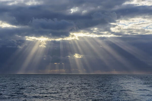 Crepuscular sunrays shining through the clouds over the North Sea, United Kingdom