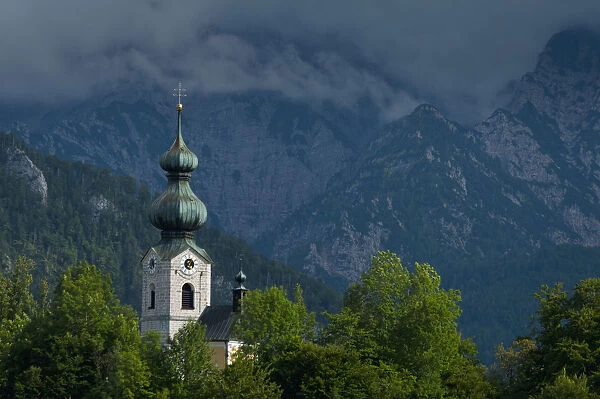 Germany, Stormy clouds behind Ruhpolding church; Bavaria