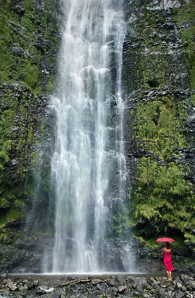 Hawaii, Maui, Kipahulu, Hana, Woman Stands With Umbrella At The Base Of Waterfall