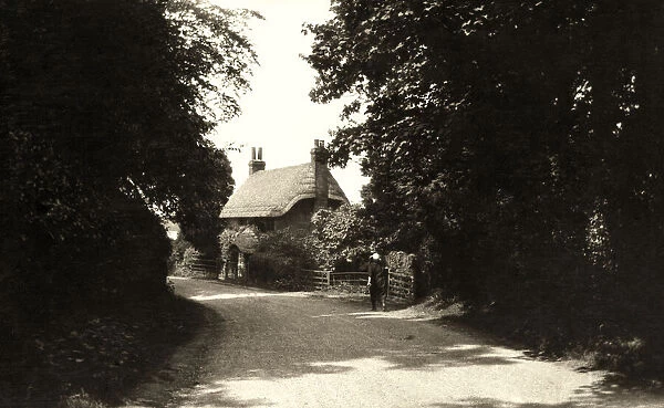 Negative early 20th century. Social History 1925 and a lady walking in a lane towards a thatched cottage