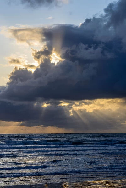 Sunbeams Flow Through Holes In The Clouds Along The Oregon Coast; Cannon Beach, Oregon, United States Of America